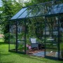 Halls Gewächshaus Icon Planthouse 8, grünes Gartenhaus mit Pflanzen und Sitzgelegenheit.