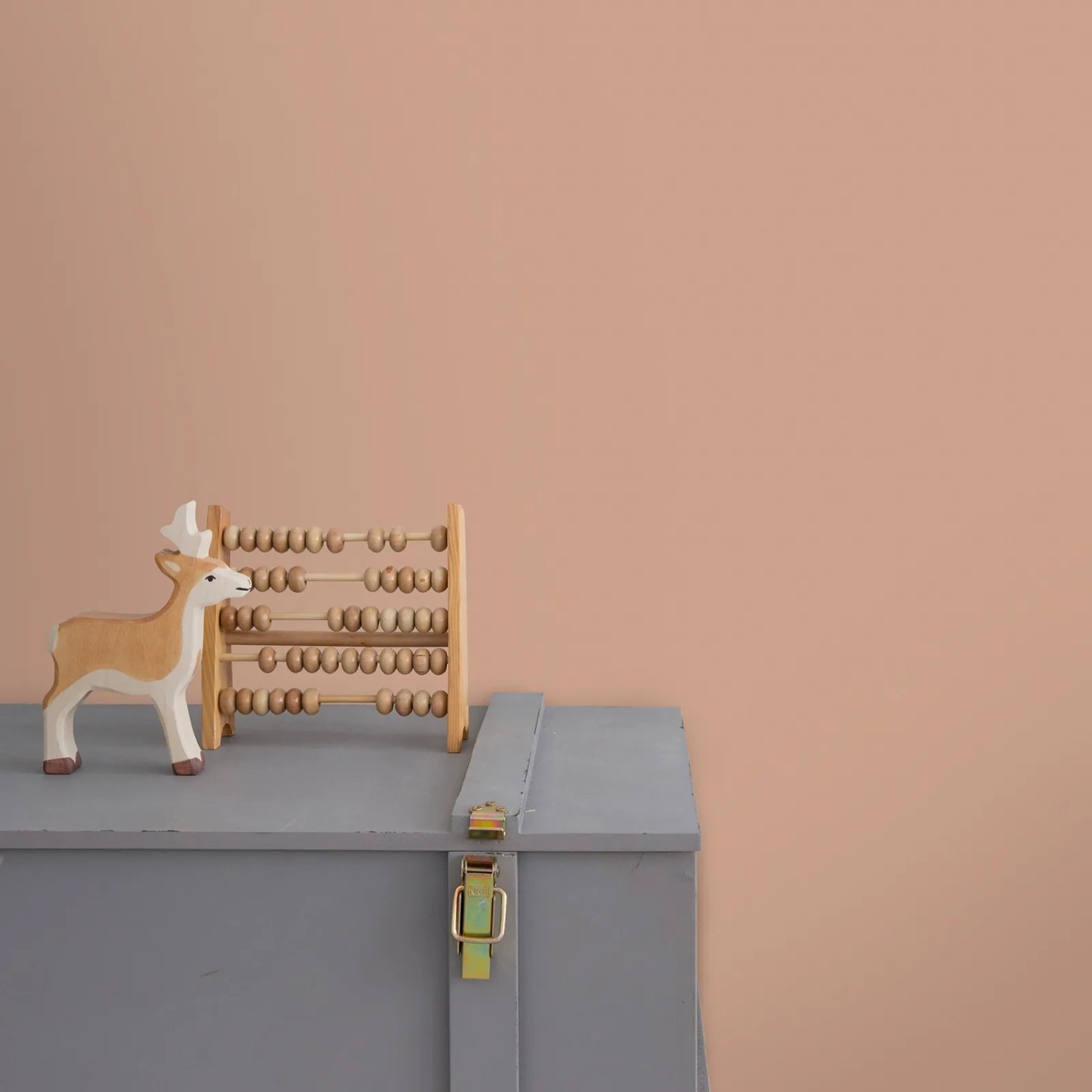 Little Dutch Wandfarbe Faded Rust Rosa, extra matt, mit Deko auf grauem Schrank vor farbiger Wand.