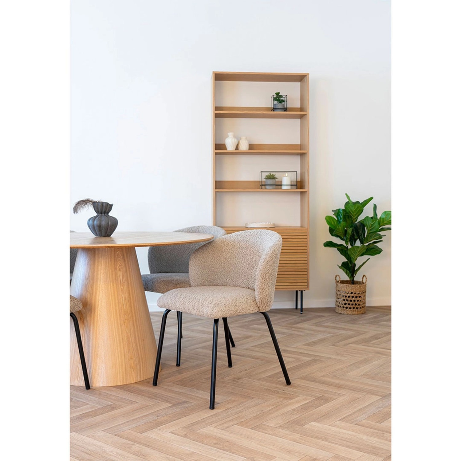 Beiger ebuy24 Safira Esszimmerstuhl mit schwarzen Metallbeinen vor Esstisch und Regal.