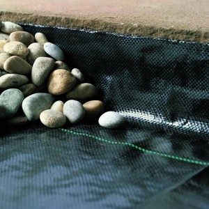 Unkrautblocker Folie (2,0 m x 100 m) unter Steinen, schützt vor Unkraut im Garten.