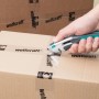 Wolfcraft Profi-Messer schneidet Paketband. Sicherheitsmesser mit Trapezklinge in Aktion.