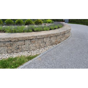 Geschwungene Gartenmauer aus Diephaus Maximo High Muschelkalk Mauersteinen, mit Lavendel und grauem Weg.