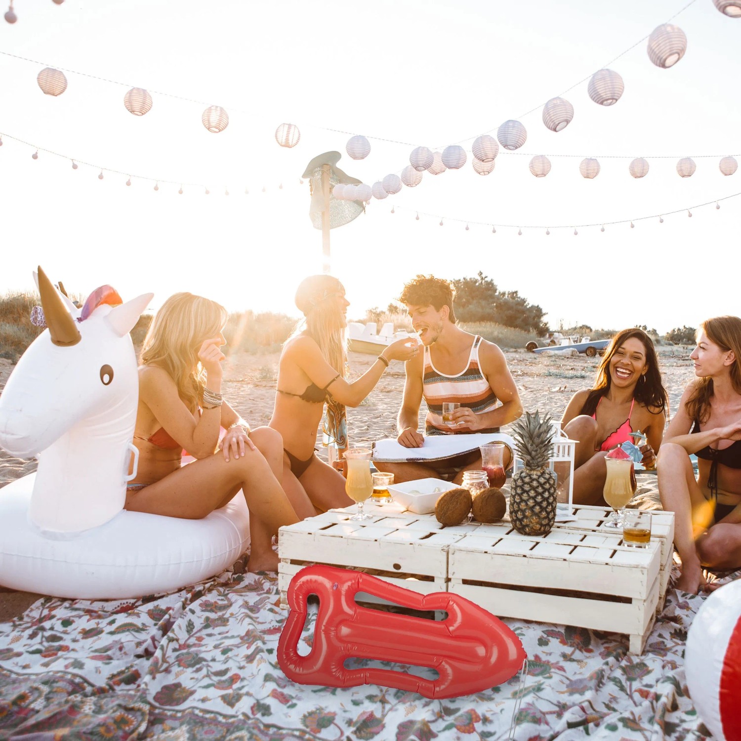 Rote aufblasbare Rettungsboje aus Kunststoff auf einer Decke bei einer Strandparty. Perfekt als Kostümzubehör oder Deko.