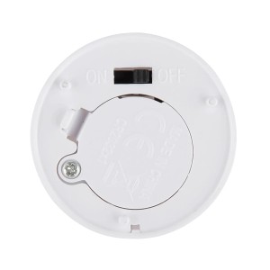 Detailansicht der Unterseite eines weißen LED-Teelichts aus Kunststoff mit Batteriefach und Schalter.