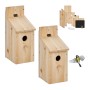 2er Set Nistkästen aus Tannenholz mit Klappdach und Sitzstange, als Bausatz gezeigt. Ein Vogel fliegt zum Vogelhaus.