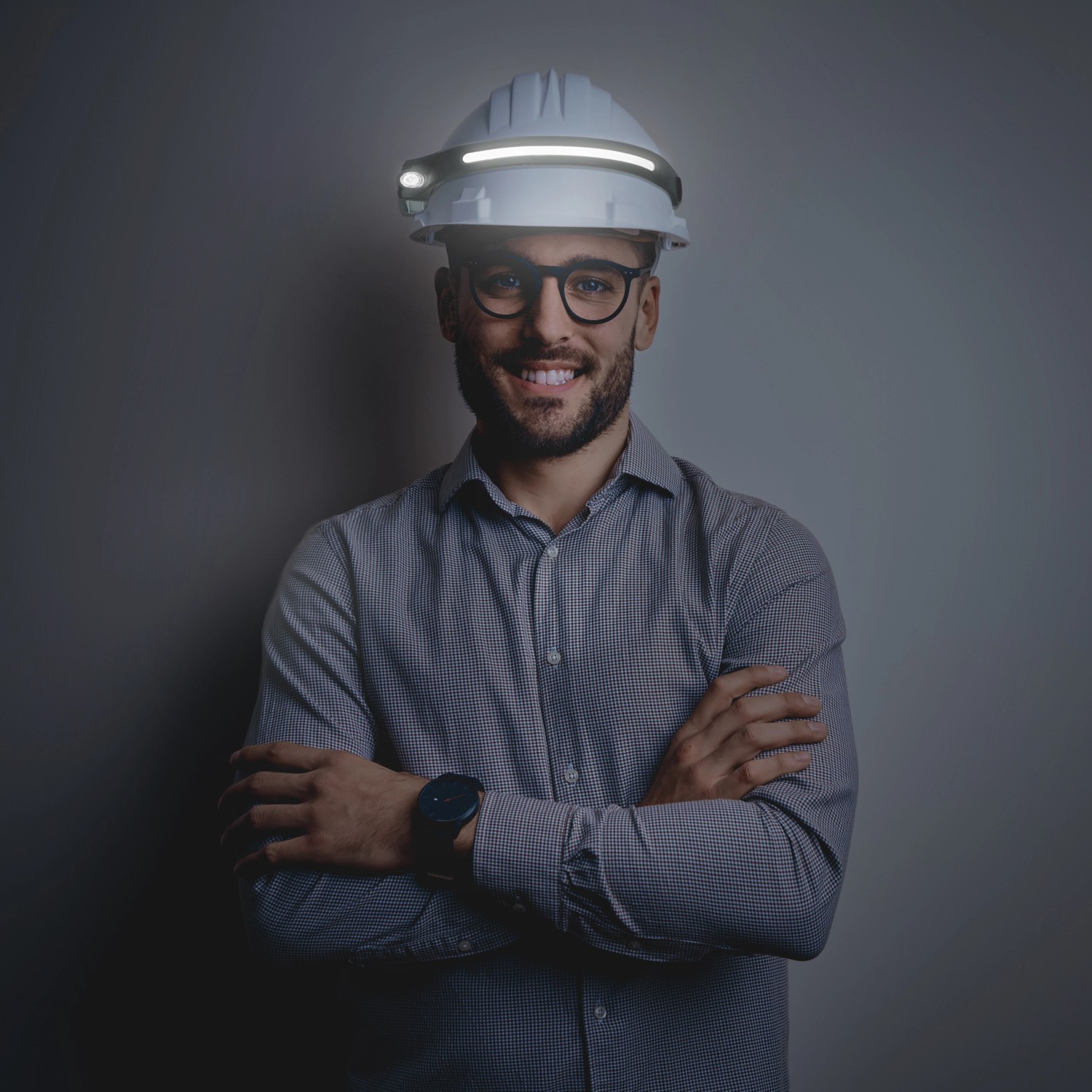 Mann mit LED's Work Akku-Stirnlampe am Helm. Dimmbare, wiederaufladbare Taschenlampe mit Gestensteuerung.