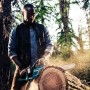 Mann sägt Baumstamm mit Makita Akku-Kettensäge DUC353Z. Leistungsstark und handlich.