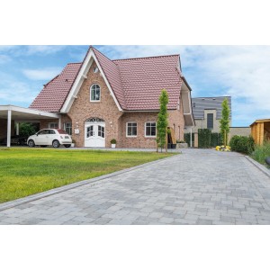 Graue Diephaus Pflastersteine Collo auf einer gepflasterten Einfahrt vor einem Haus.
