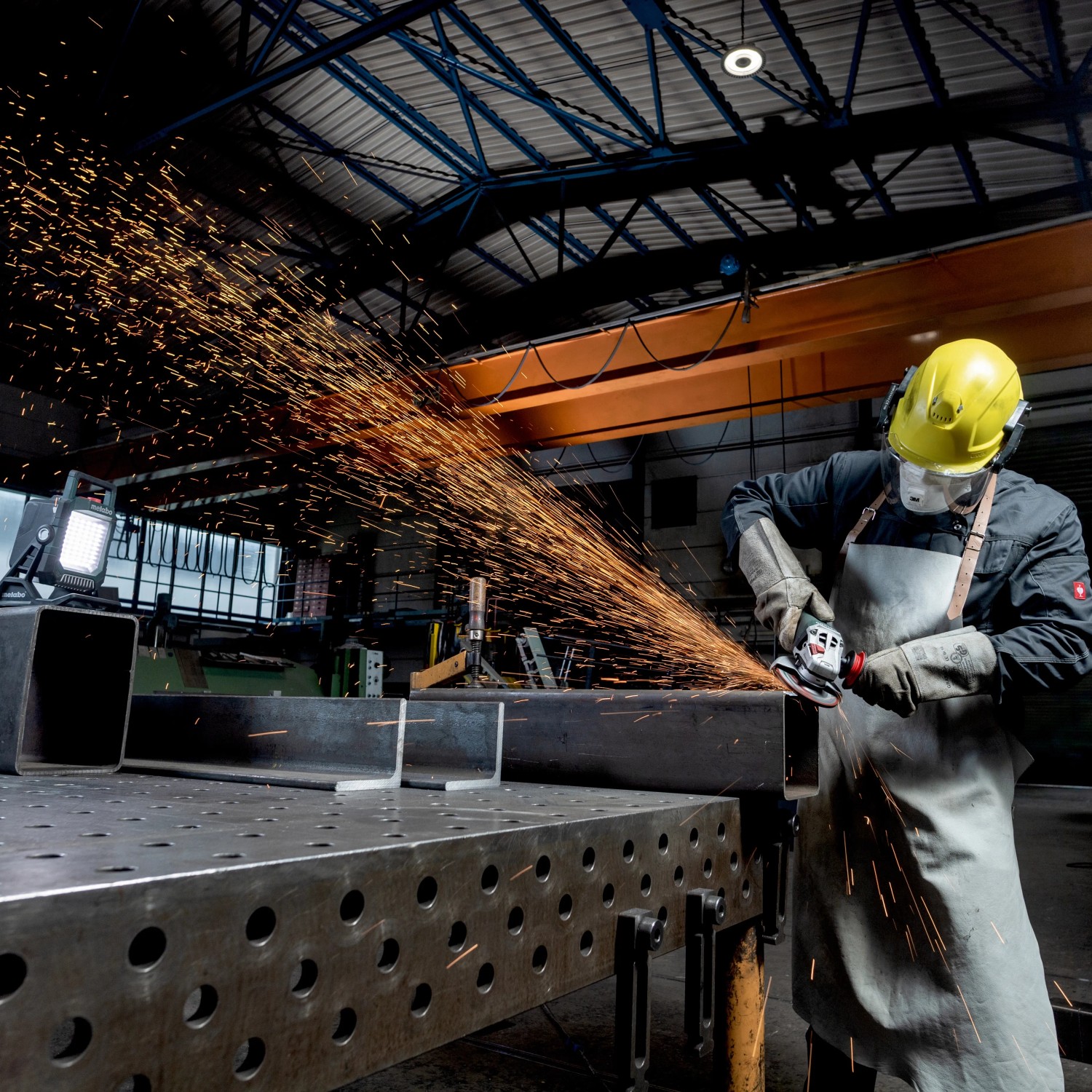 Metabo Akku-Baustrahler BSA 18 LED 4000 Solo im Einsatz beim Schleifen von Metall.