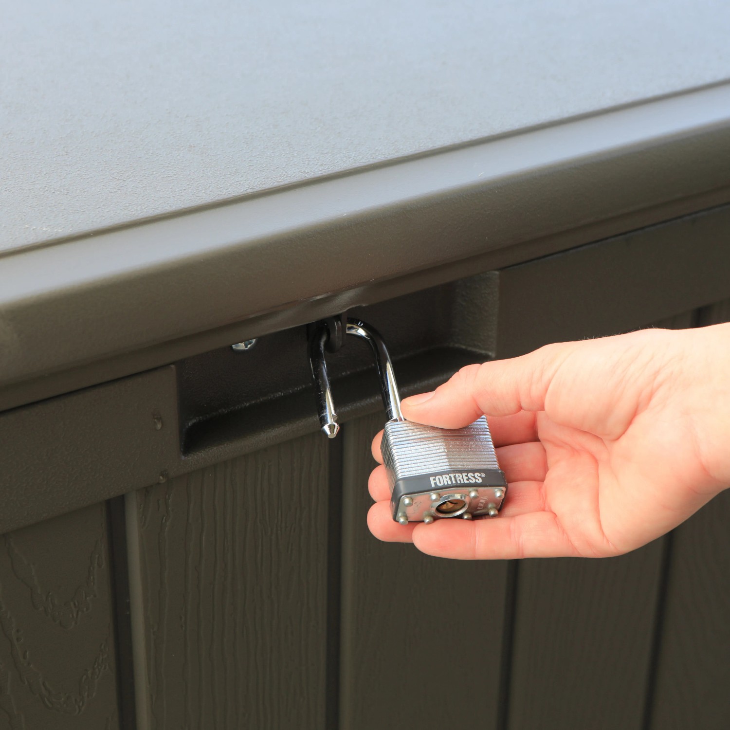 Detailaufnahme: Dunkelbraune Lifetime Gartenbox wird mit Vorhängeschloss gesichert.