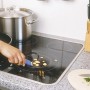 LUX Universalschaber im Einsatz zum Reinigen eines Ceranfelds von Speiseresten.