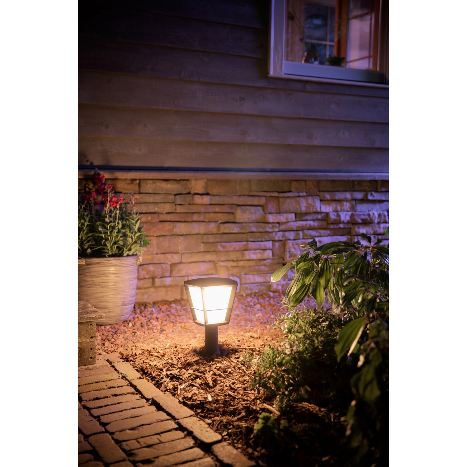 Philips Hue Econic Sockelleuchte im Garten. Schwarze LED Außenleuchte mit warmweißem Licht.
