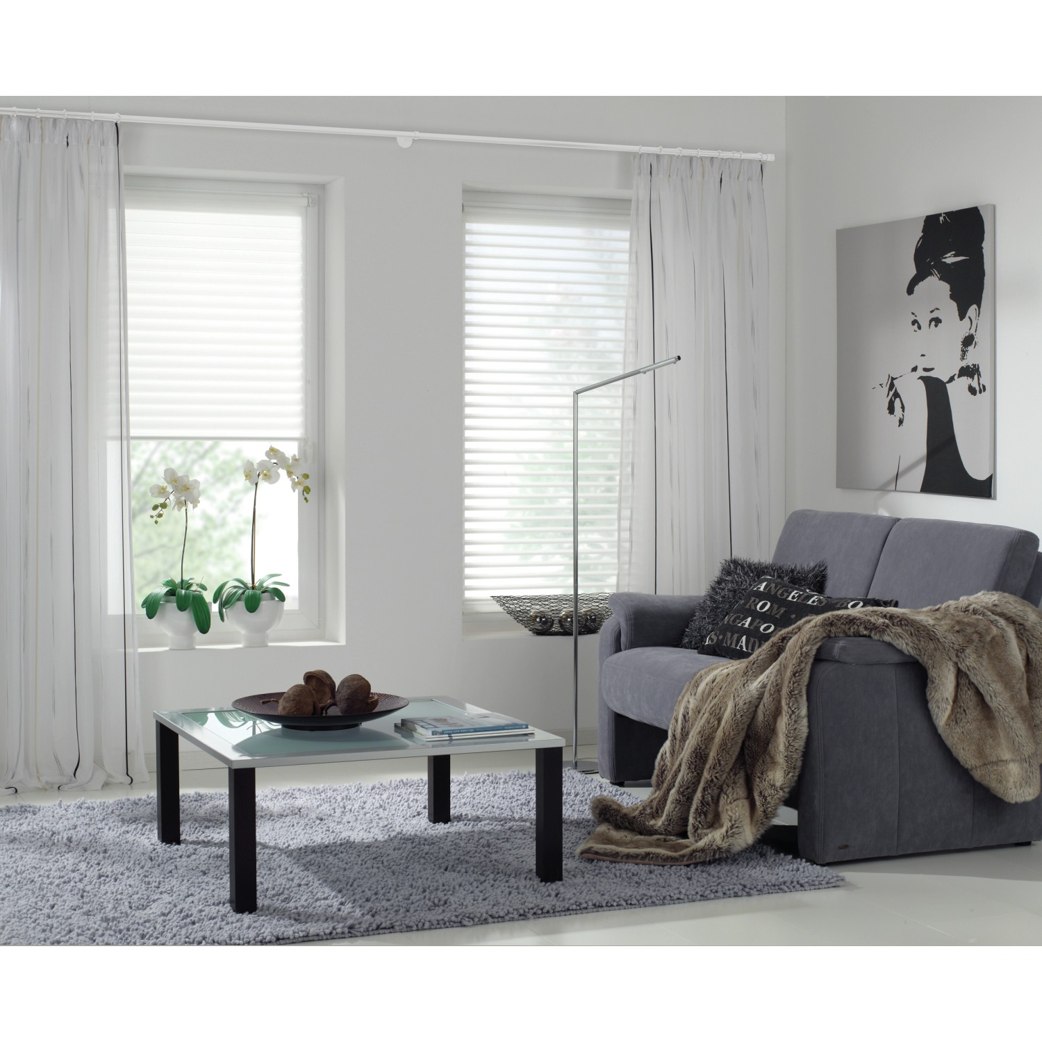 Wohnraum mit weißen Gardinenringen, passend zu Stilgarnituren und Gardinenstangen.