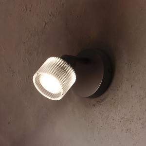 Schwarzer Philips LED-Spot Horen mit geripptem Glas, leuchtend an dunkler Wand. Schwenkbar für Wand/Decke.