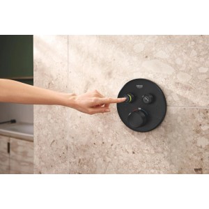 Schwarzes, rundes Grohe SmartControl Unterputz-Thermostat an Wand, Hand bedient Tasten. Für Dusche/Badewanne.