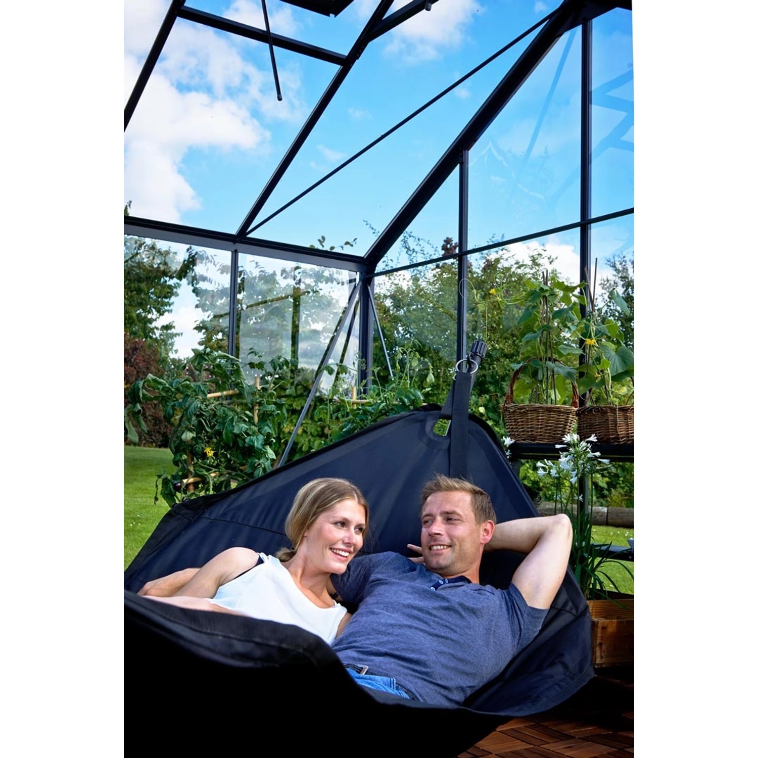 Juliana Gewächshaus Orangerie 15: Paar entspannt in Hängematte im Gewächshaus mit schwarzem Rahmen.