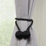 Schwarzer Gardinia Raffhalter Flex-S mit Magnet, 2 Stück, an grauer Gardine.