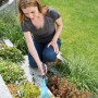 Frau benutzt Gardena combisystem-Kleinbesen im Garten zur Beetpflege.