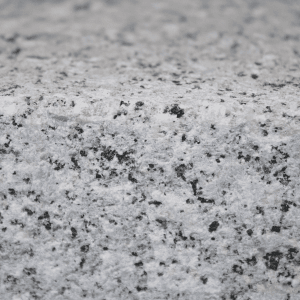 Nahaufnahme: Graues Galamio Granitpflaster, gesägt, gespalten und geflammt. Robust und ideal für Außenbereiche.