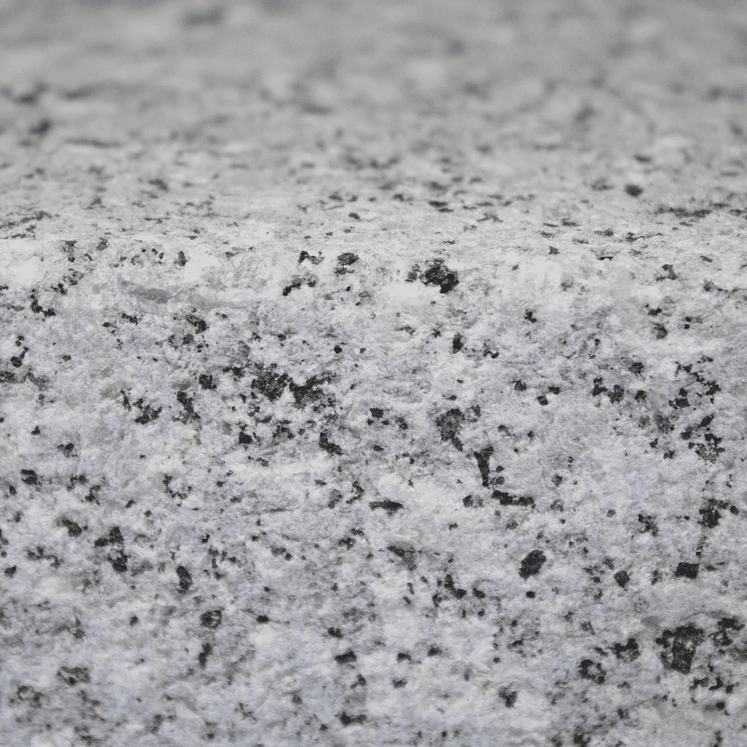 Nahaufnahme: Graues Galamio Granitpflaster, gesägt, gespalten und geflammt. Robust und ideal für Außenbereiche.