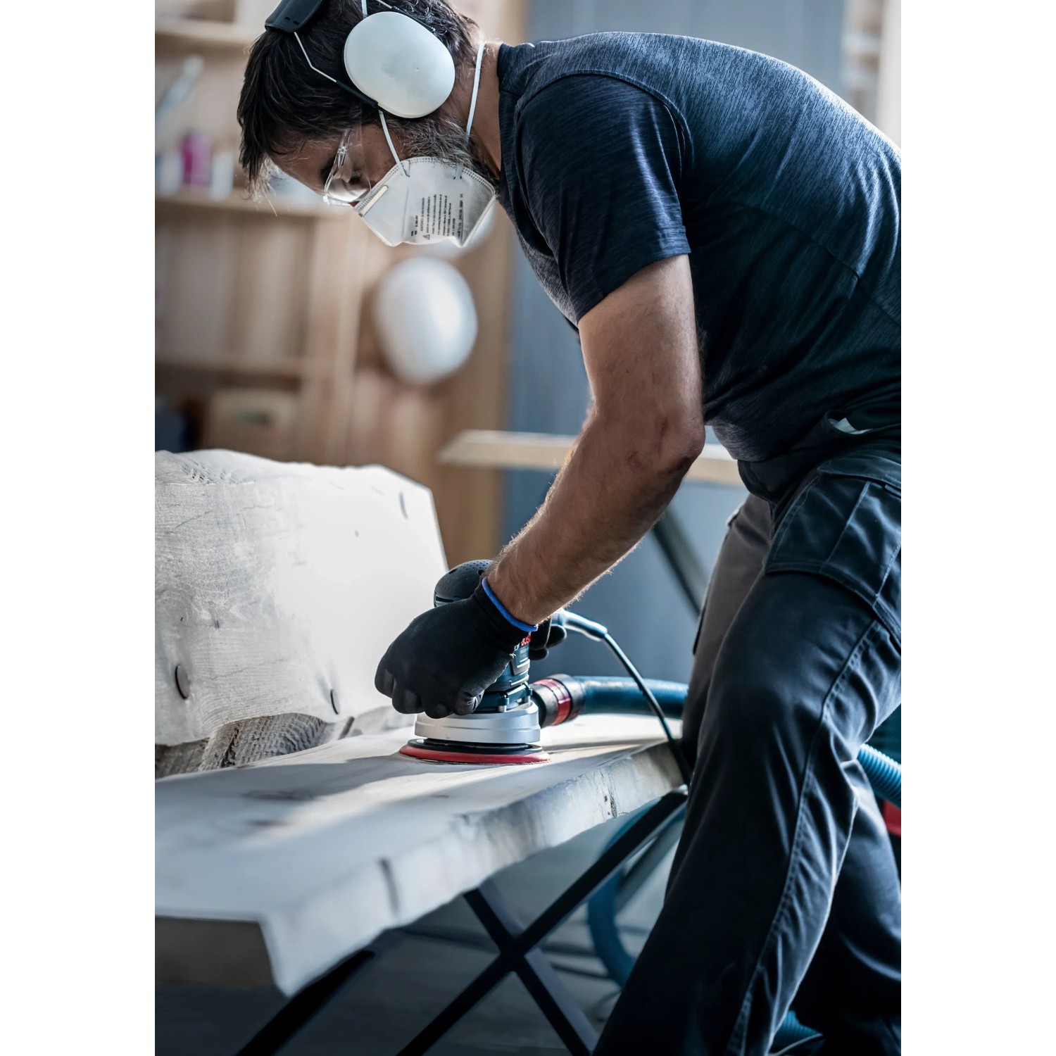 Mann schleift Holz mit Bosch Exzenterschleifer und M480 Schleifblatt K240.