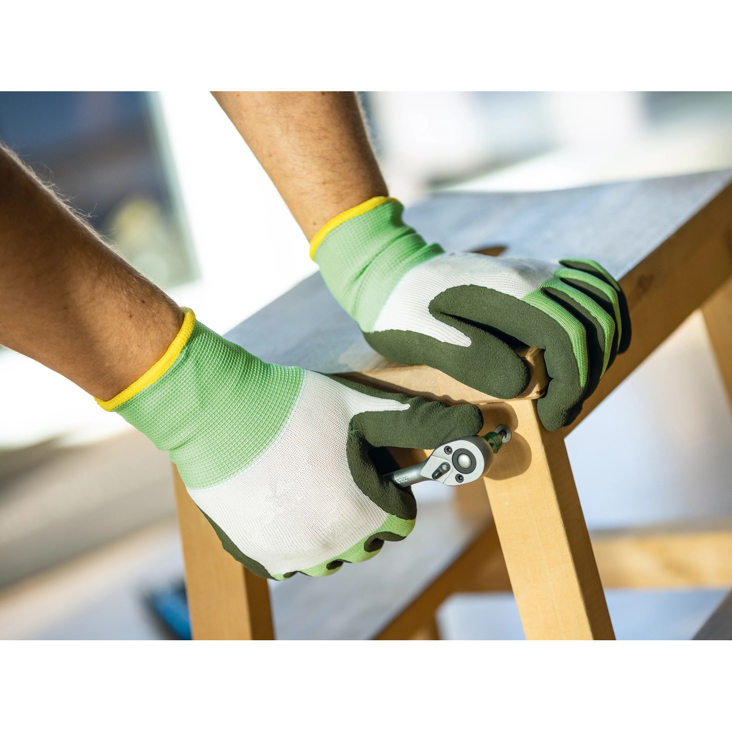 Hände mit LUX Arbeitshandschuhen Eco Gr. 10 bei Montagearbeiten mit Werkzeug.