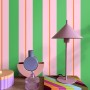 ESTAhome Tapete mit grünen und rosa Streifen, akzentuiert durch orange Linien, an einer modern dekorierten Wand. Vliestapete.