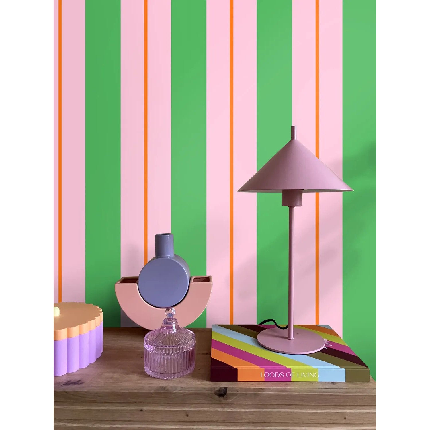 ESTAhome Tapete mit grünen und rosa Streifen, akzentuiert durch orange Linien, an einer modern dekorierten Wand. Vliestapete.