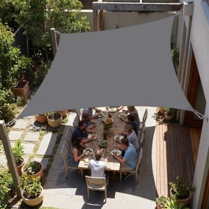 Anthrazitfarbenes, rechteckiges Sonnensegel aus Polyester schützt Essbereich auf Terrasse vor Sonne. UV-Schutz für Garten & Balkon.