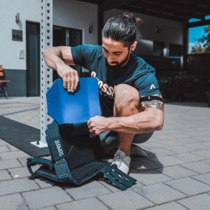 Mann setzt blaue Suprfit Sigurd 3D Bodyplate 6,2 kg in schwarze Gewichtsweste. Fitnessgerät für Sport & Training.
