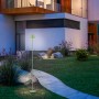 Grüne LED-Akku-Stehleuchte Euria (125 cm) im Garten. Dekorative Außenleuchte mit warmweißem Licht.