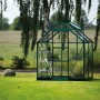 Grünes Halls Gewächshaus Icon 6 (2,5 m²) mit Glaswänden, Schiebetür und Dachfenster, auf Rasen im Garten.