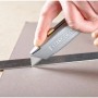 Stanley Messer 99E schneidet Material entlang eines Metalllineals.