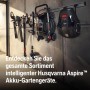 Husqvarna Aspire Akku-Gartengeräte Sortiment an einer Schiene: Laubbläser, Heckenschere, Rasentrimmer und Mähroboter.