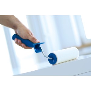 Hand hält LUX Velours-Roller (15 cm) beim Streichen auf weißer Oberfläche.