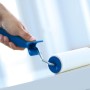 Hand hält LUX Velours-Roller (15 cm) beim Streichen auf weißer Oberfläche.