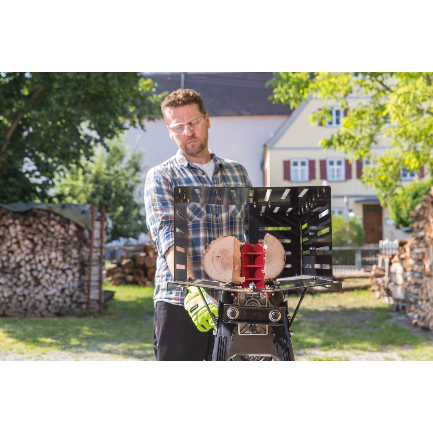 Mann bedient Al-Ko Elektroholzspalter LSH 520/5 mit Holzstück. Sicher durch Schutzabdeckung.