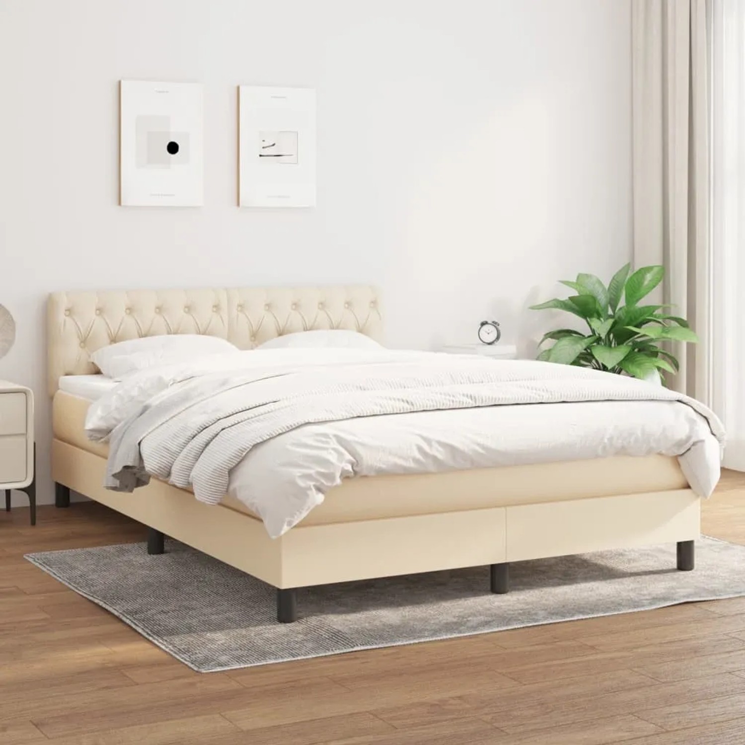 Cremefarbenes Boxspringbett (140x190 cm) mit Matratze und gestepptem Kopfteil.