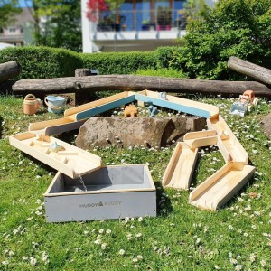 MUDDY BUDDY Wasserbahn Aqua Traveller aus Holz, natur/grau/petrol, mit Auffangbecken, im Garten aufgebaut.