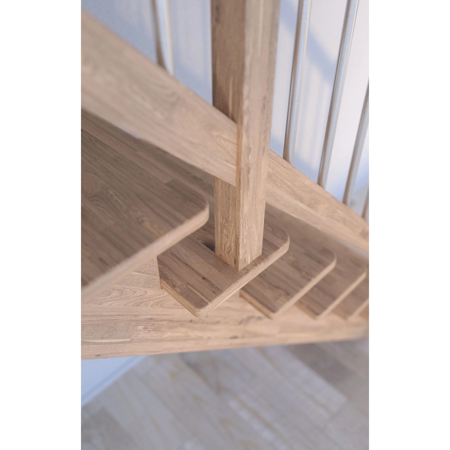 Detailaufnahme: Gerade Treppe Lindos Eiche mit weißem Holz-Edelstahl-Geländer und Setzstufen.