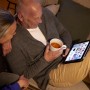 Paar entspannt mit Tablet und Tee, beleuchtet durch Philips LED E14 Tropfenform Leuchtmittel.