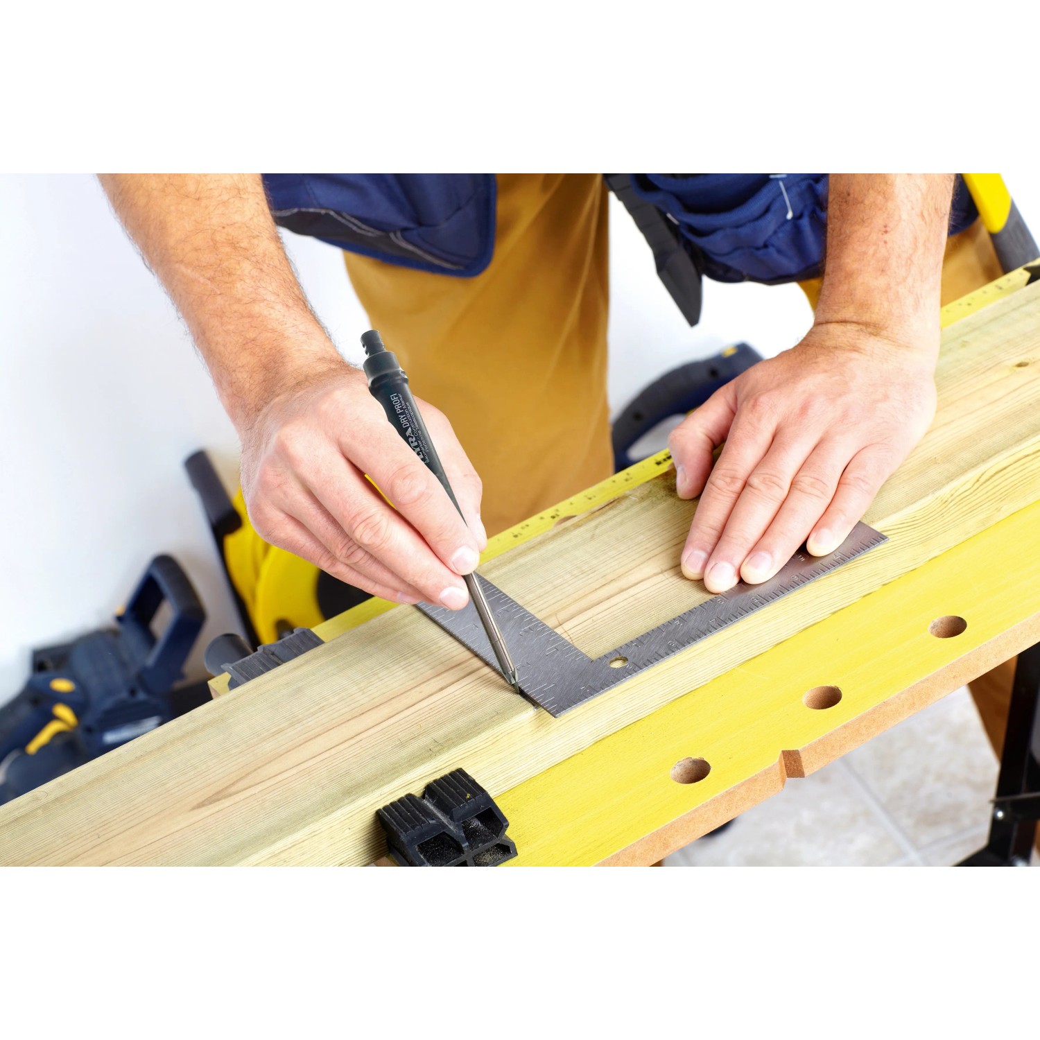 Handwerker zeichnet Linie mit Dry Profi Baumarker und Winkel auf Holz.