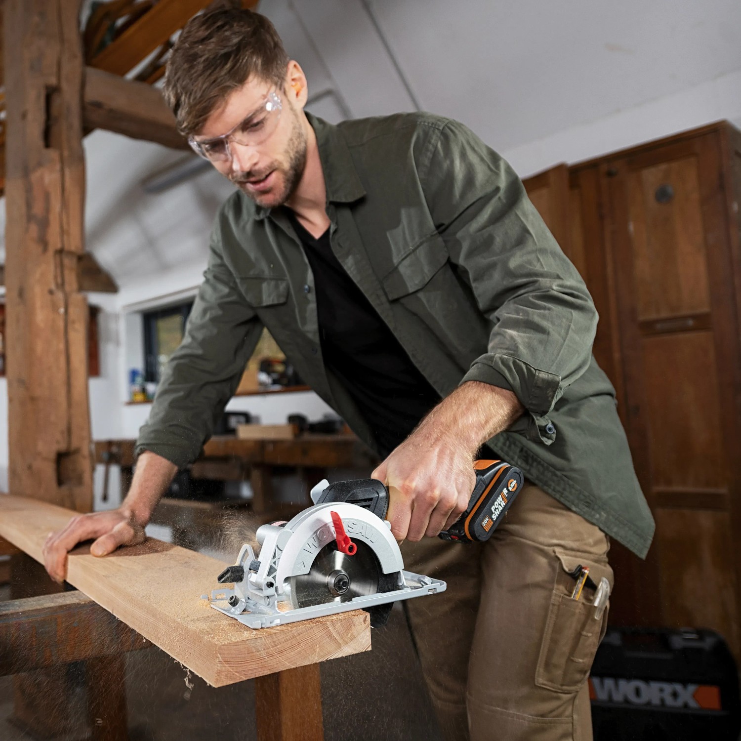 Mann sägt Holz mit Worx Akku-Handkreissäge WX531.9. Kompakte Säge für präzise Schnitte.