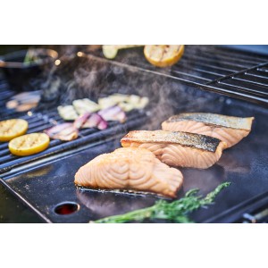 Char-Broil Grillplatte Essential aus Gusseisen mit Lachs, Gemüse und Zitrone auf dem Grill.