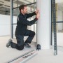 Mann markiert Linie mit Bosch Professional Linienlaser GCL 2-15 an Säule. Prüfwerkzeug für präzises Nivellieren.