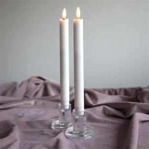 Zwei weiße Star Trading LED Stabkerzen aus Echtwachs mit warmweißer Flamme in Glasständern.
