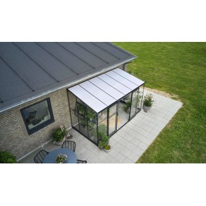 Schwarzes Halls Anlehngewächshaus Qube Lean-to 612 mit Glasfront und Pflanzen auf Terrasse.