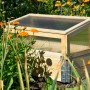Frühbeet Pflanzbeet Größe M aus Holz mit Polycarbonat-Aufsatz im Garten.