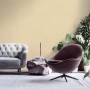 Beige-gelbe Vliestapete Uni Matt Strukturiert im Wohnraum mit Sofa und Sessel.