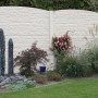 Betonzaun-Bogenplatte Fels, 200x45x3 cm, als Sichtschutz im Garten mit Pflanzen und Dekoration.